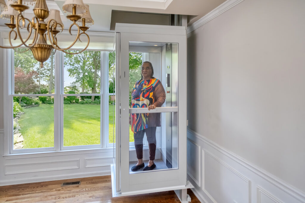 A glass-cab residential elevator with sunlit views
